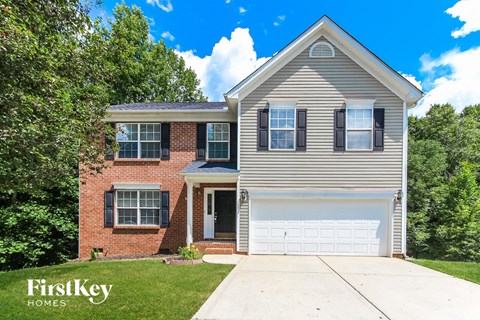 a home with a white garage door and a brick house