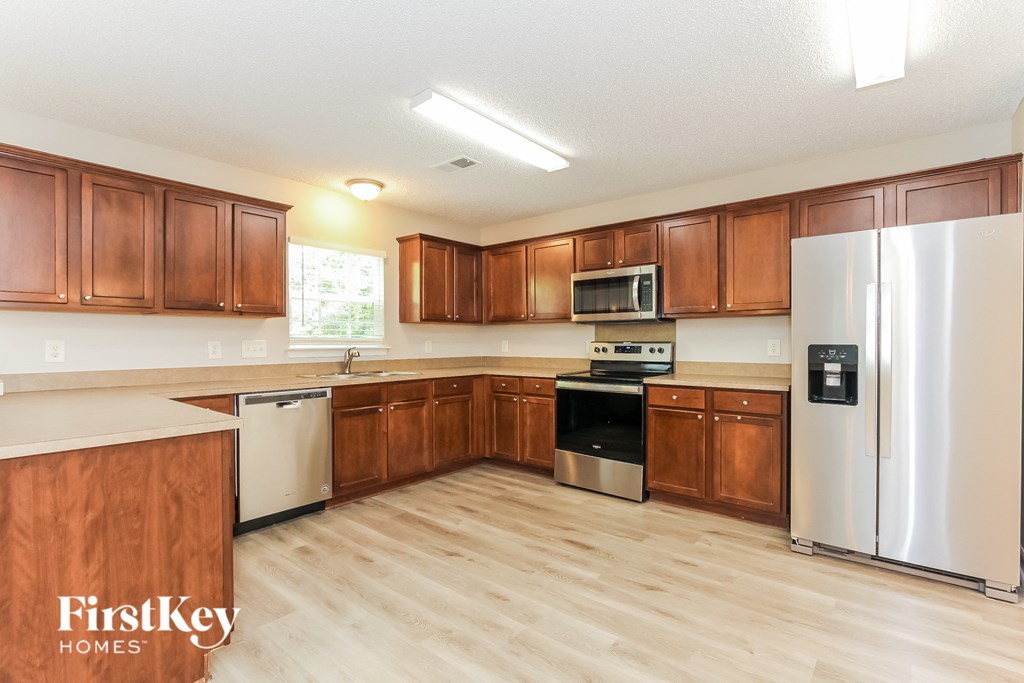 a kitchen with wooden cabinets and stainless steel appliances