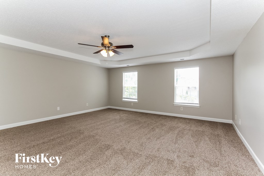 a living room with carpet and a ceiling fan