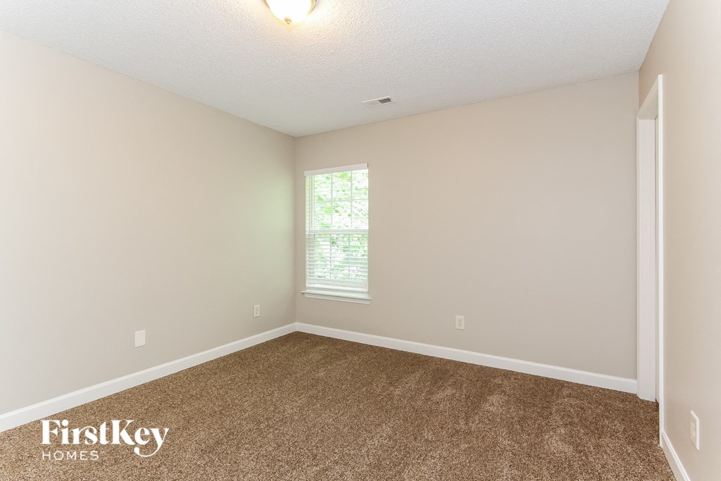 an empty room with carpet and a window