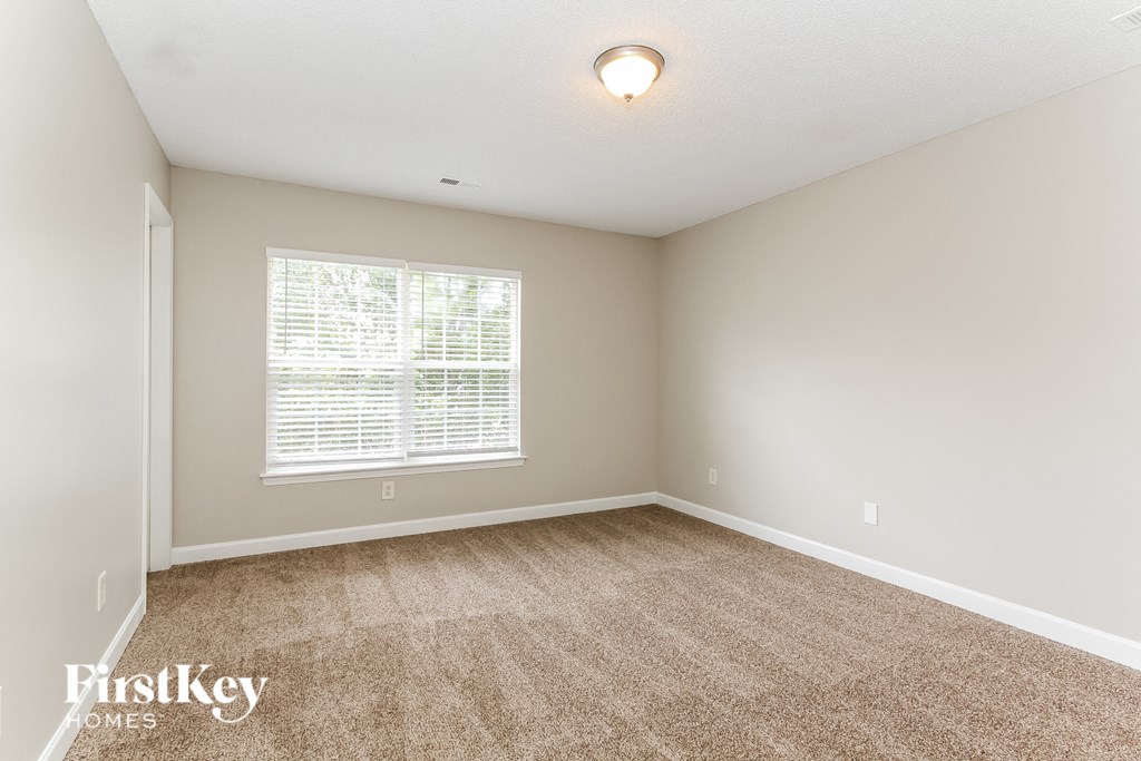 a spacious living room with carpet and a large window