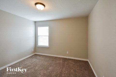 the upstairs bedroom with carpet and a window