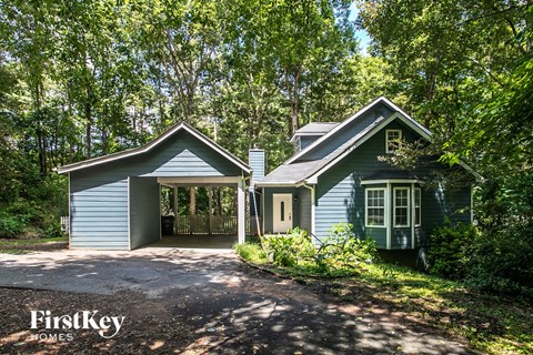 a blue house with a driveway and a garage door