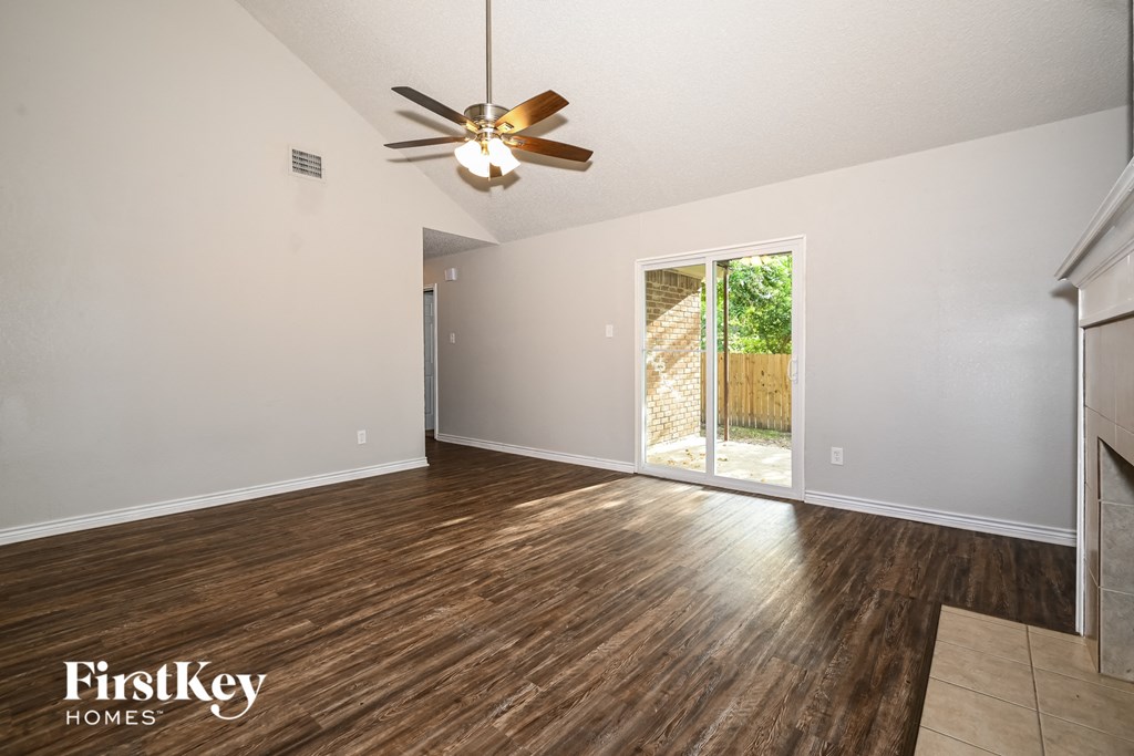the living room of an empty house with a ceiling fan