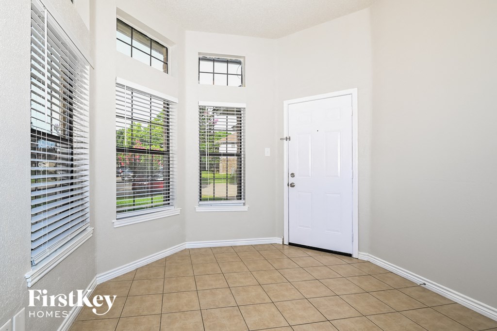 the entryway of a home with a white door and windows