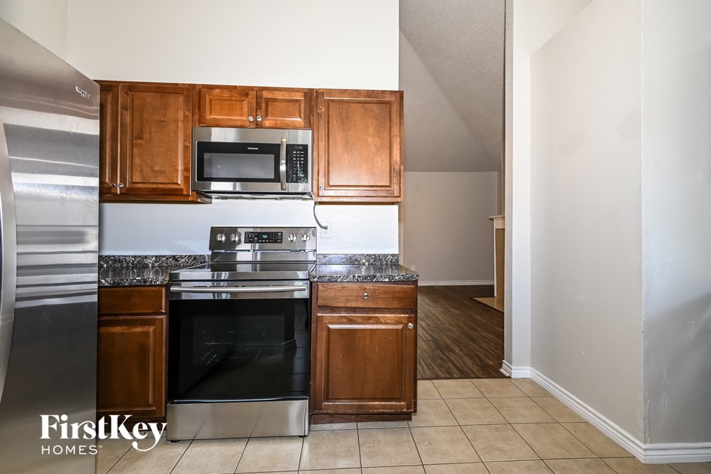 a kitchen with wooden cabinets and stainless steel appliances