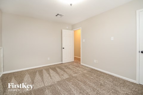 a bedroom with carpet and a door to a closet