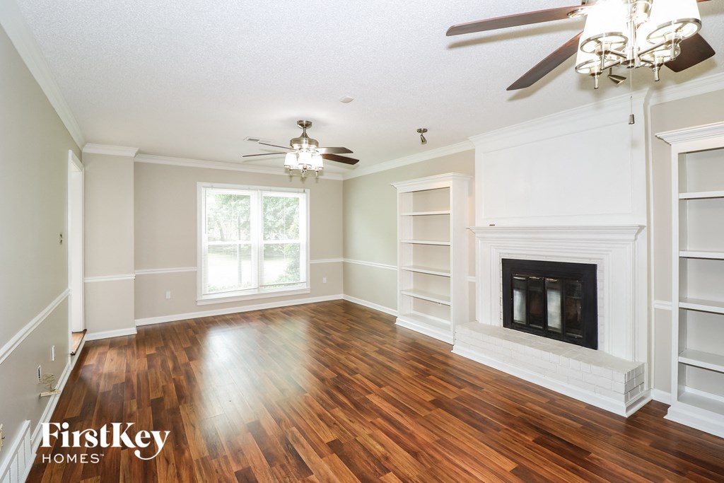 the living room of a house with a fireplace and wooden floors