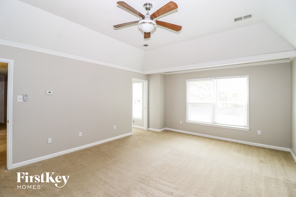the living room of an empty house with a ceiling fan