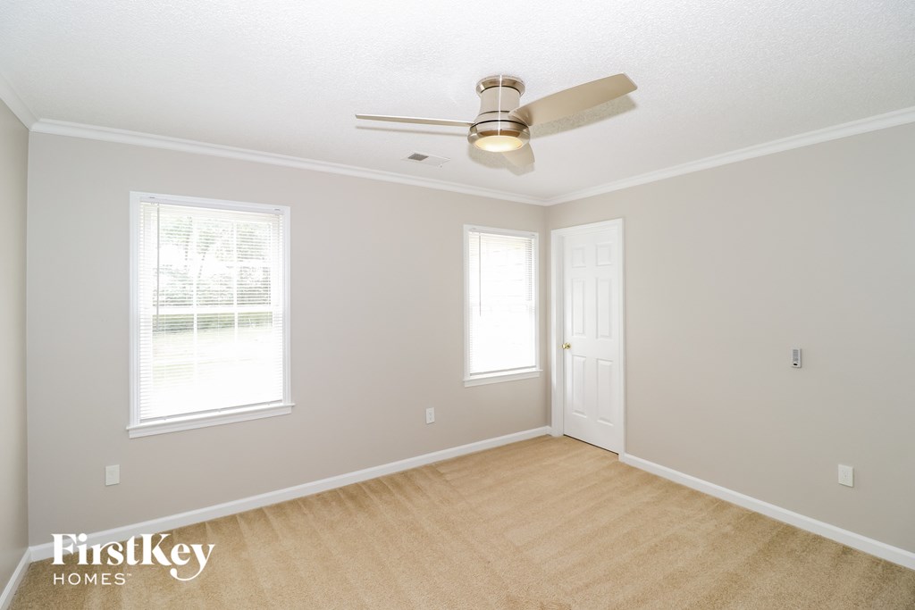 a living room with a ceiling fan and a door