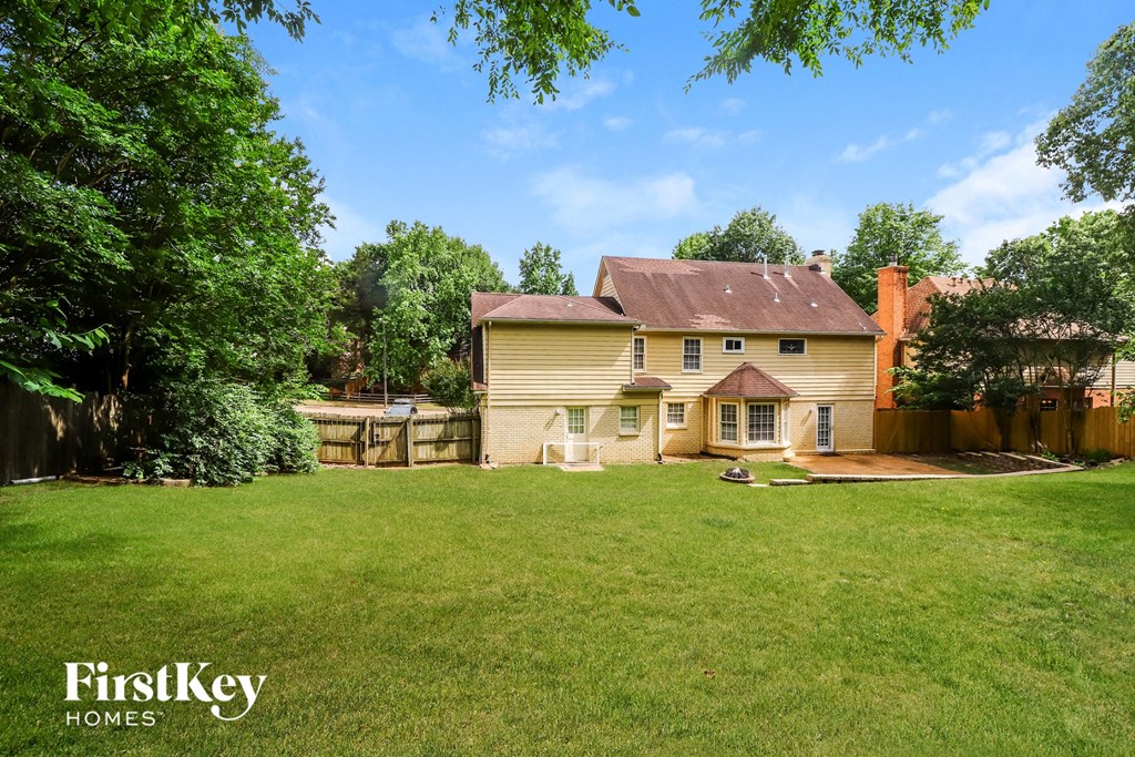 a backyard with a house and a yard and a fence