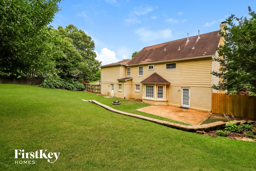 the back of a house with a yard and a fence