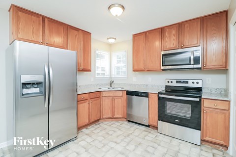 A kitchen with wooden cabinets and a refrigerator.