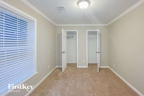 a bedroom with a large window and a door to a closet