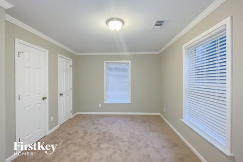 a empty room with a white door and a window and blinds