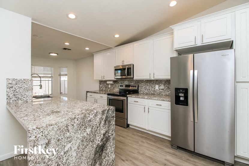 A kitchen with granite countertops and stainless steel appliances.