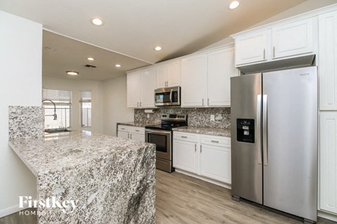 A kitchen with granite countertops and stainless steel appliances.