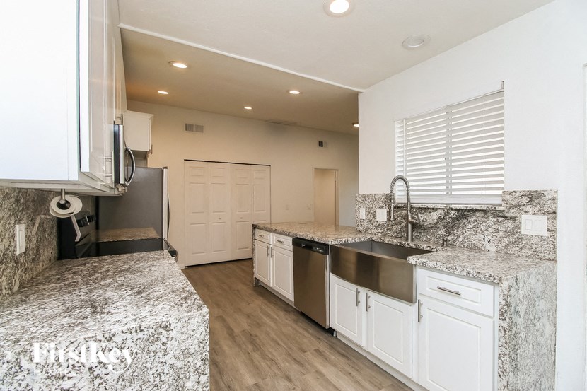 A kitchen with granite countertops and stainless steel appliances.