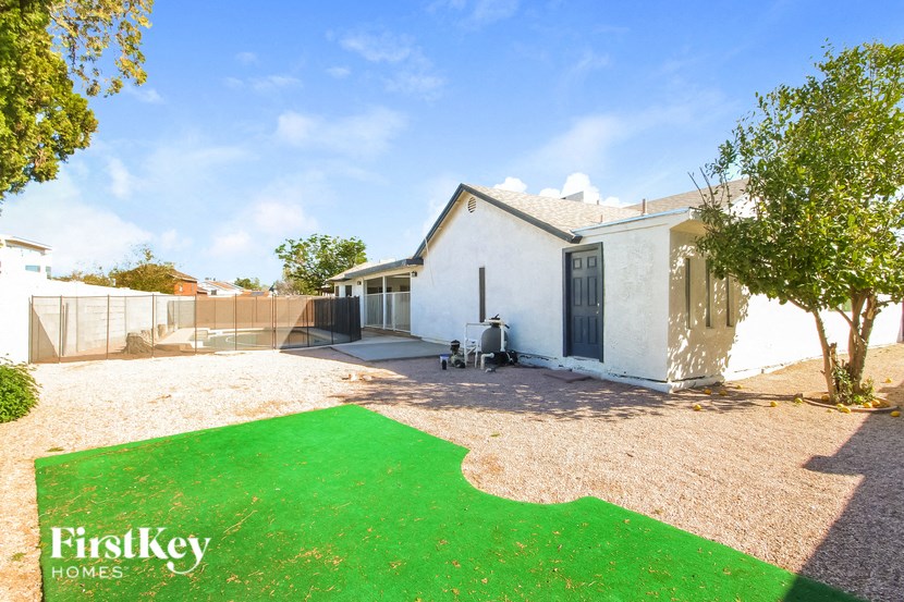 A white house with a green lawn in front of it.