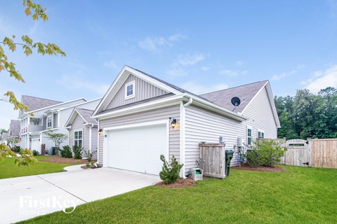 a white house with a white garage door and a green lawn