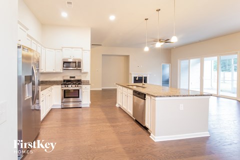 a large kitchen with white cabinets and stainless steel appliances