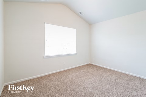 a bedroom with carpet and a window
