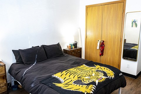a bedroom with a bed with a yellow tiger blanket