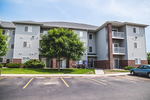 an apartment building with a car parked in a parking lot