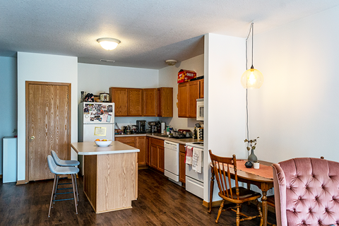 A kitchen with a table and chairs.