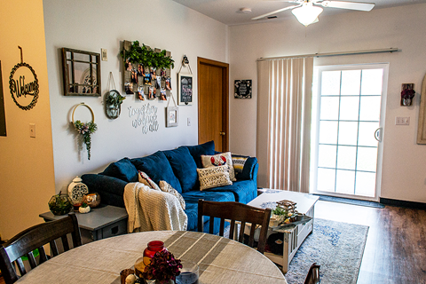 a living room with a blue couch and a dining room table
