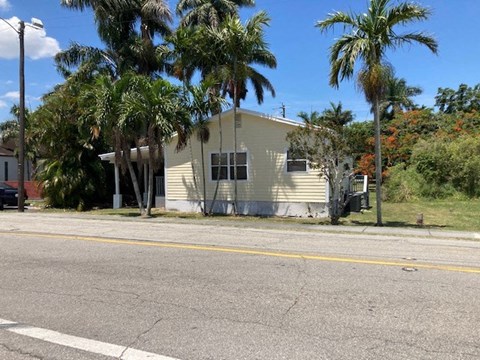A house with a fence and a car parked in front.