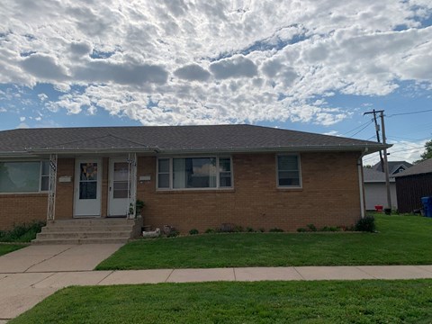 a brick house with a cloudy sky in the background