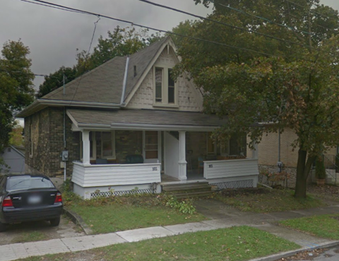 A small house with a car parked in front.