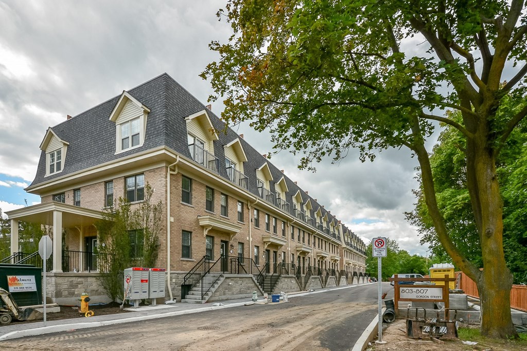 A large house with a grey roof and a sign that says no parking.