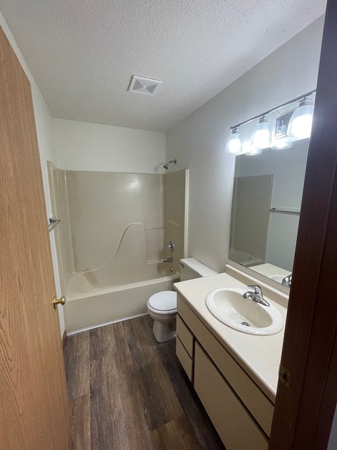 A bathroom with a toilet, sink, and shower.
