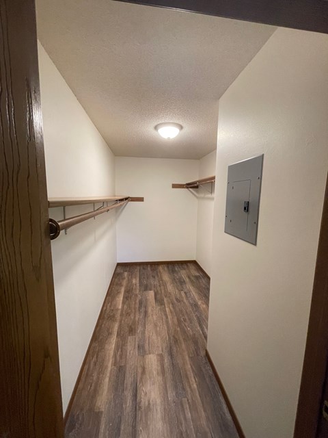 A long hallway with wood floors and white walls.