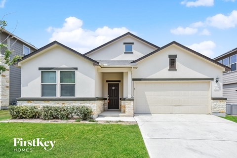 A house with a garage and a driveway in front of it.