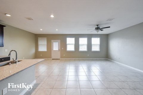 A spacious room with a fan and tile flooring.