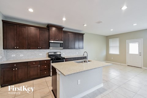 A kitchen with brown cabinets and a granite countertop.