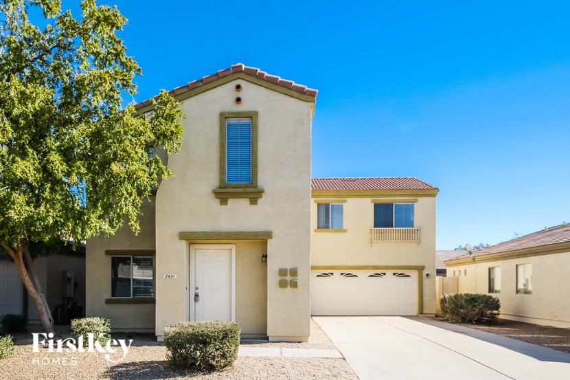 A beige house with a white door and windows.