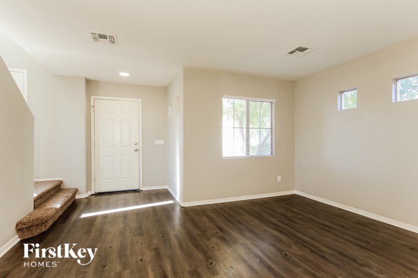 A room with wooden floors and a bench under a window.