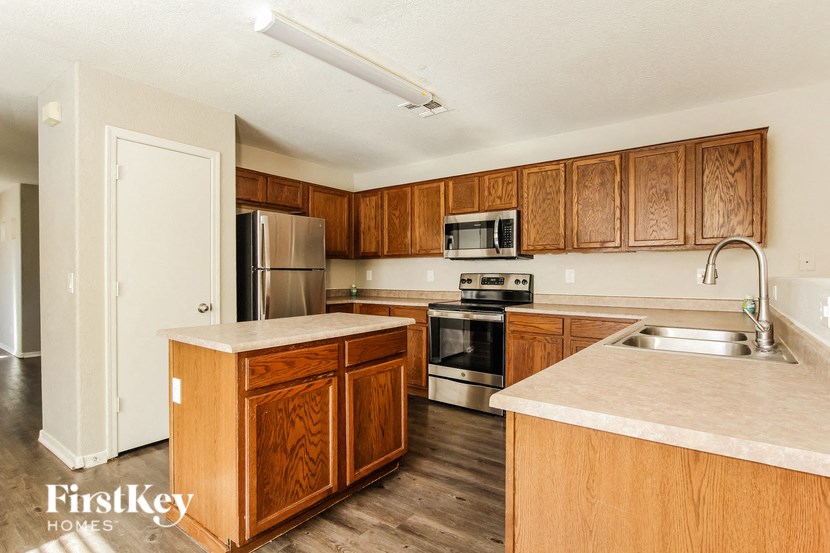 A kitchen with wooden cabinets and a white fridge.