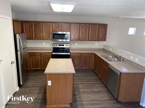A kitchen with wooden cabinets and a stove top oven.