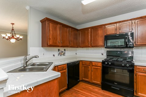a kitchen with black appliances and wooden cabinets