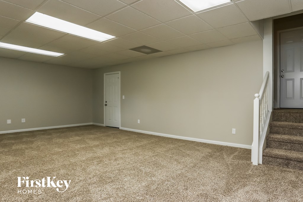 a room with carpeted stairs and a door to a hallway