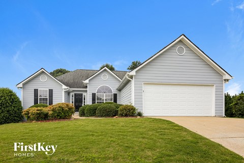 a blue and white house with a lawn in front of it