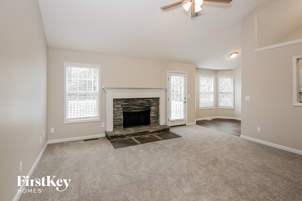 the living room of an empty house with a fireplace