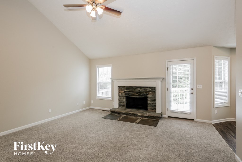 a living room with a fireplace and a ceiling fan