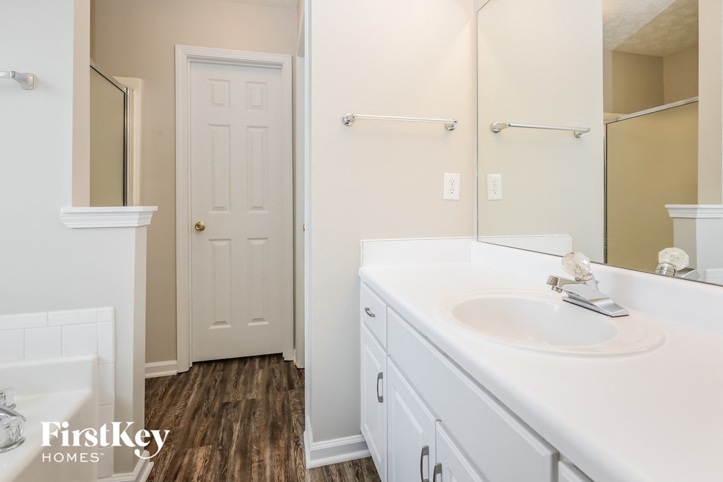 a bathroom with white cabinets and a sink and a mirror