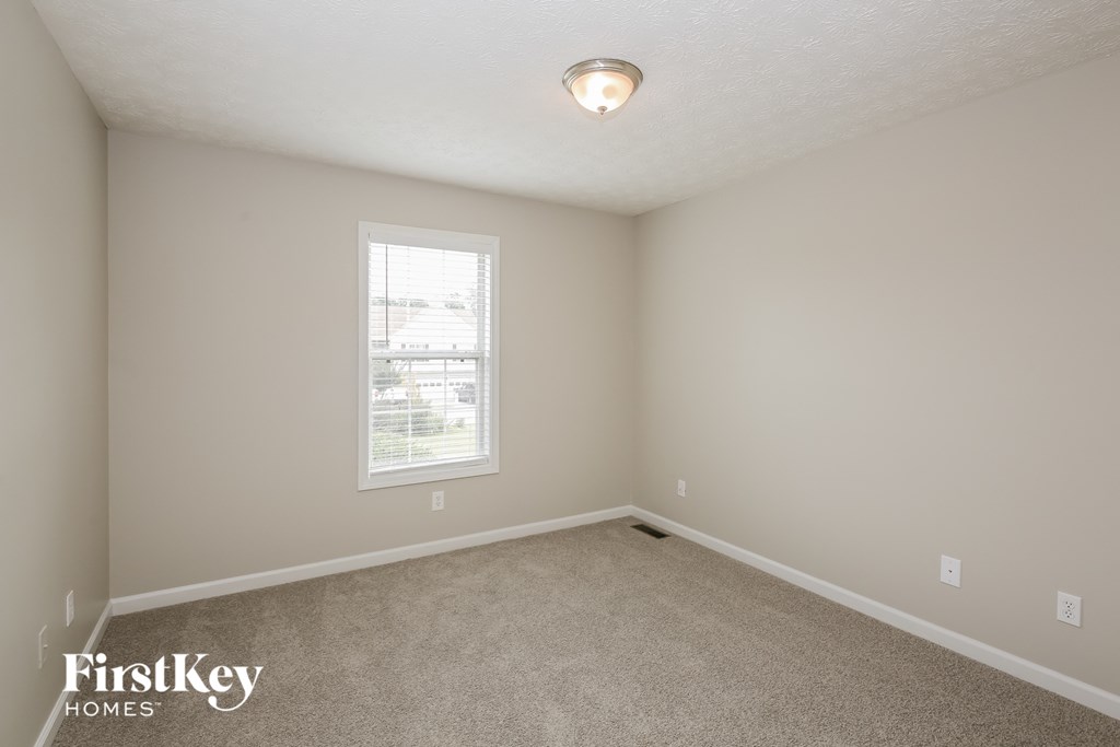 a bedroom with a carpeted floor and a window